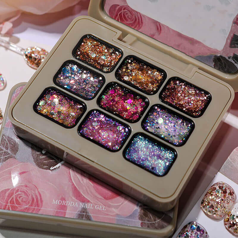 Set of glittery nail gel polishes in a beige case on a decorative background with roses.