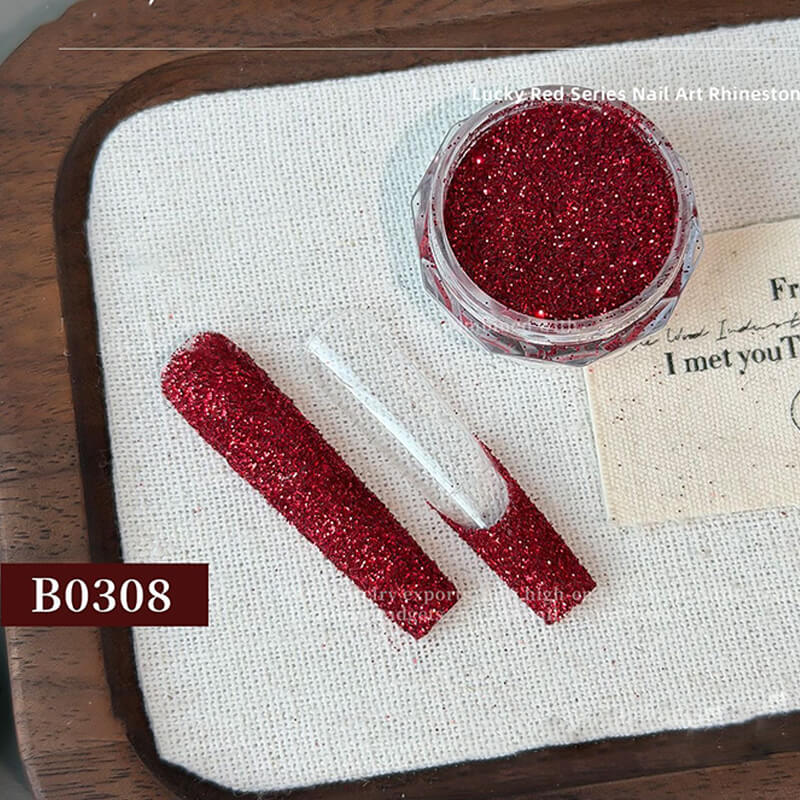 Red glitter nail art powder with a brush and label on a wooden surface