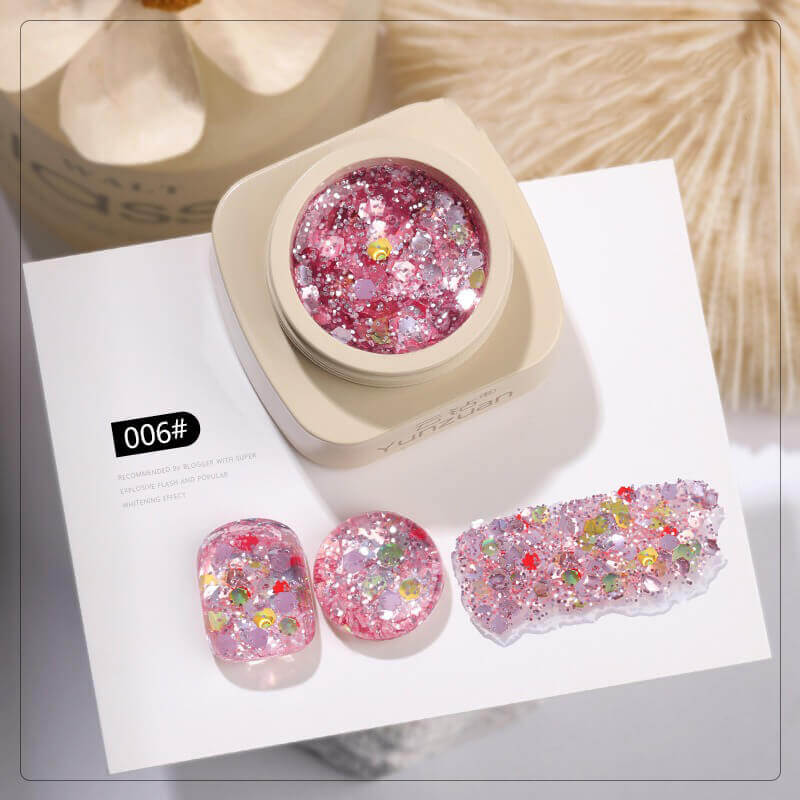 Pink glittery nail art design with a container and samples on a white background