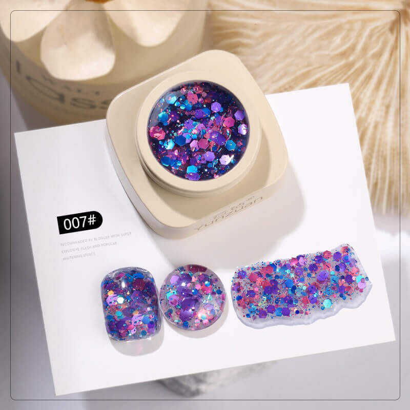 Colorful glittery nail art gel in a container with samples on a white background