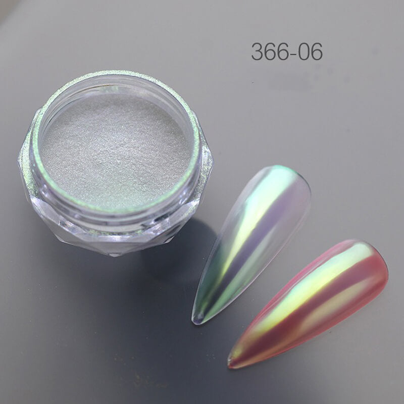 Jar of metallic powder with a colorful nail tip on a gray background