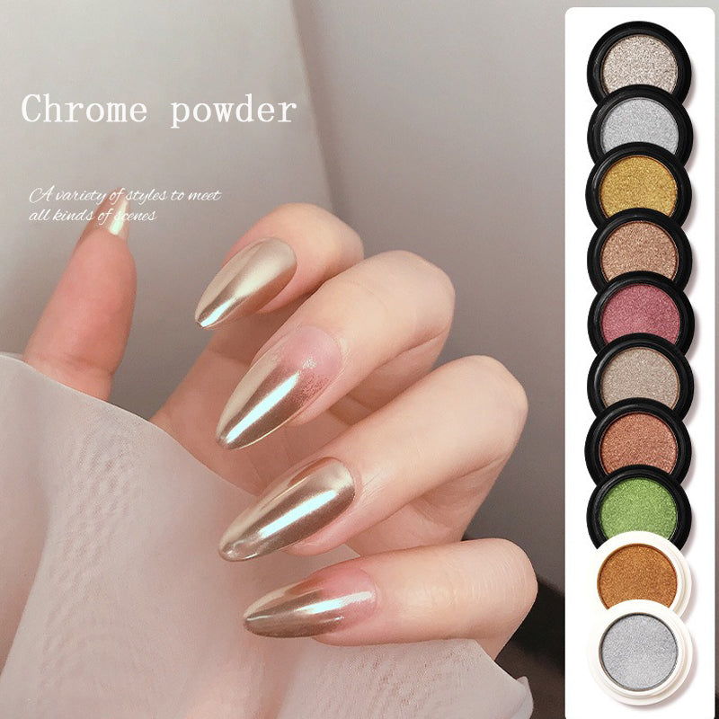 A variety of chrome nail powder colors displayed in piles with a hand showing a manicured nail with a chrome finish.
