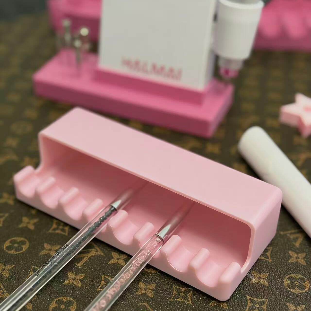 Pink nail art tool holder with two tools on a patterned surface