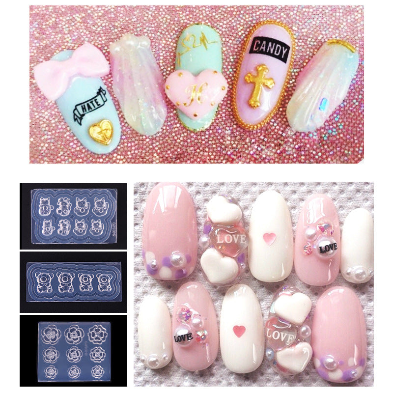 A set of silicone nail molds with various designs including a bear, hearts, and floral patterns, displayed on a nail art setup with decorative elements.