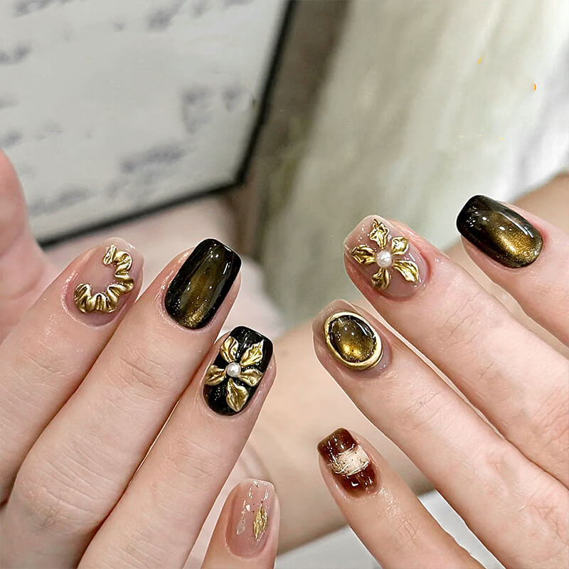 Nails with gold and brown design on a neutral background