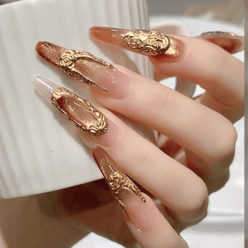 Nails with gold decorative designs on a neutral background