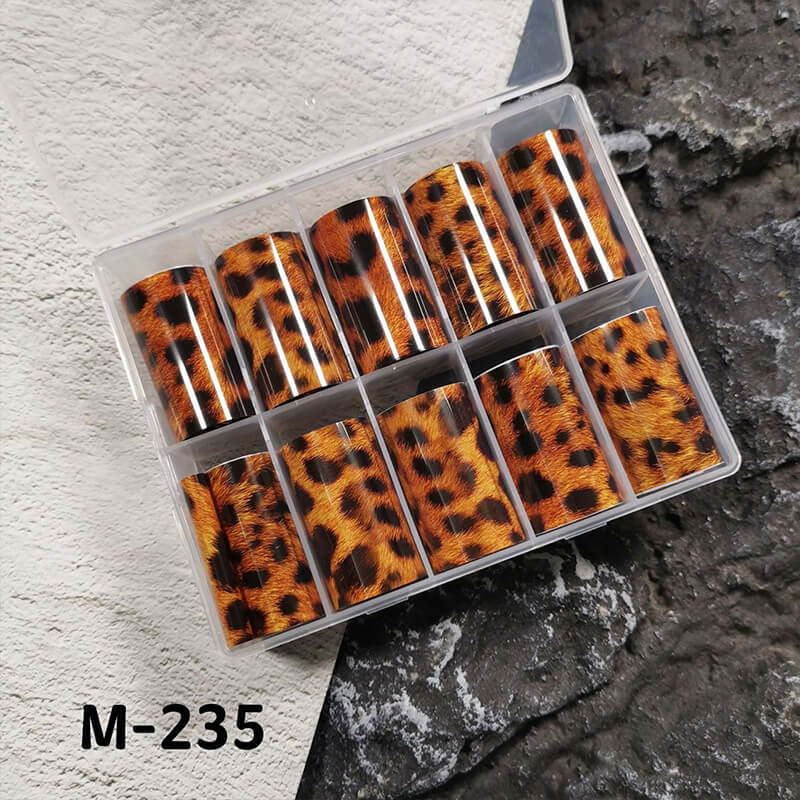 Set of leopard print nail foils in a clear plastic case on a textured surface.