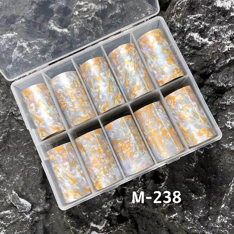 Set of marble nail foils in a clear plastic case on a textured surface.
