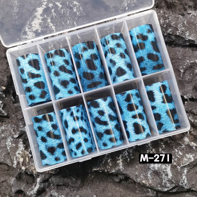 Set of blue leopard print nail foils in a clear plastic case on a stone surface