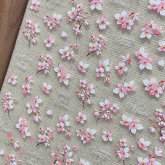 A sheet of nail art stickers featuring pink cherry blossom designs on a beige background with decorative text.