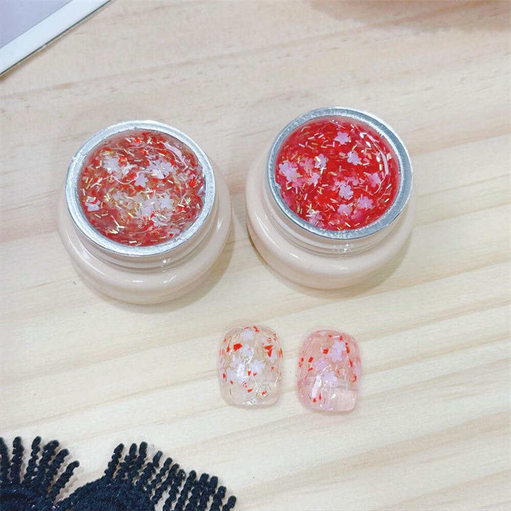 Hand model wearing cherry blossom glitter gel for romantic spring manicure