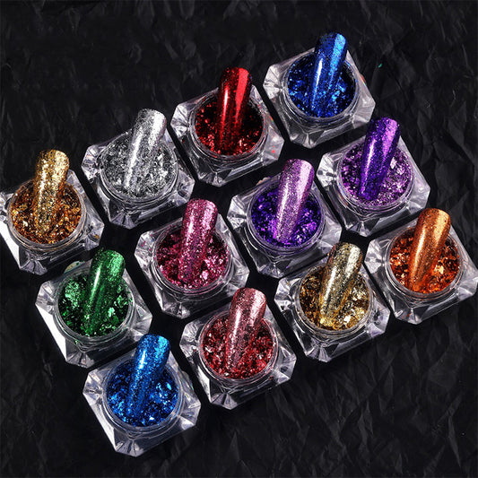 A collection of nail art decorations featuring glitter and sequins in various colors displayed in small square containers.