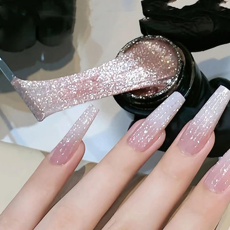 Nails with glittery pink spider gel polish and a bottle of nail polish in the background