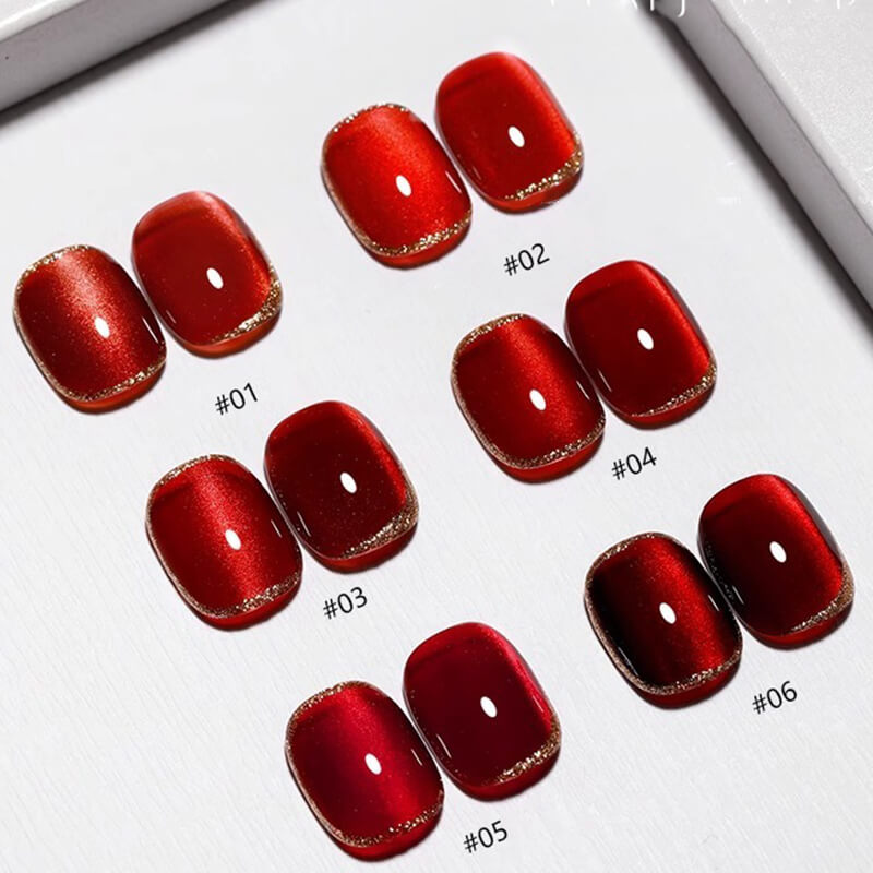 Various swatches of red cat eye nail gel polish with different shades and finishes displayed on a surface.