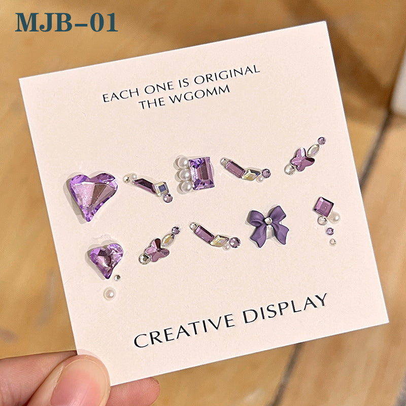 A collection of nail gem designs displayed on a card, with various shapes and sizes of rhinestones mainly in purple and clear colors, labeled as 'MJ-01' and 'Creative Display'.