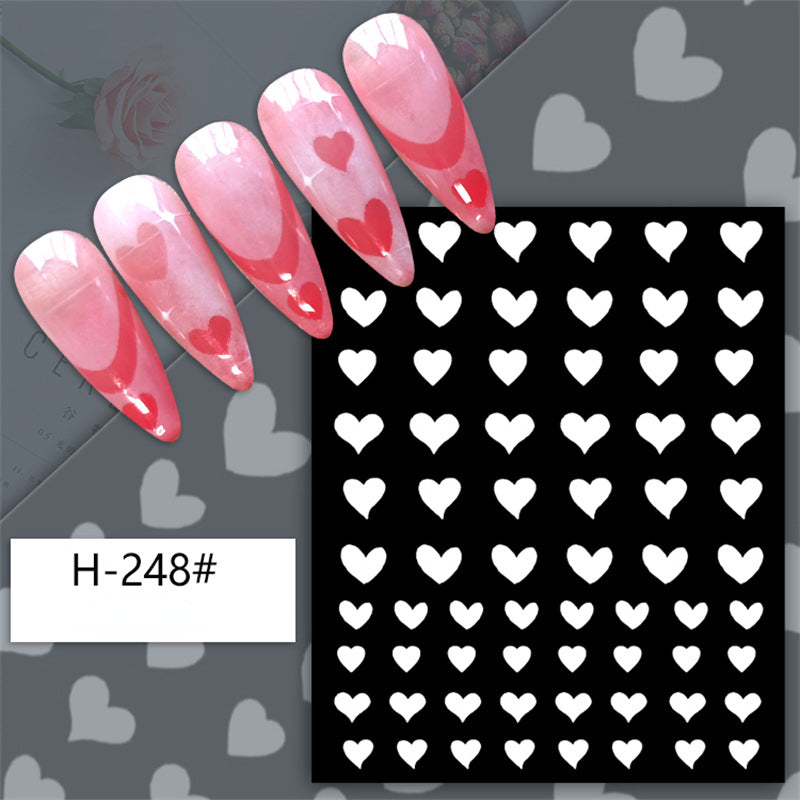 A set of nail stickers with various designs including stars, hearts, a bear, and a butterfly, predominantly in pink and black colors.