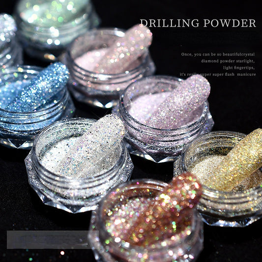 Eight small jars of sparkling nail powder in various colors, with the word 'DILLING POWDER' written on each jar lid. The jars are filled with fine glitter powder, reflecting light and color.