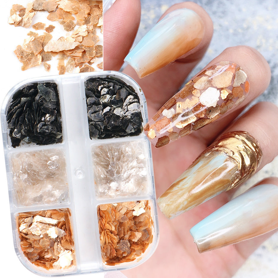 A set of nail art stickers with various designs, including some that resemble marble and others with a shiny, iridescent finish. The stickers are shown alongside a set of loose mica powders.