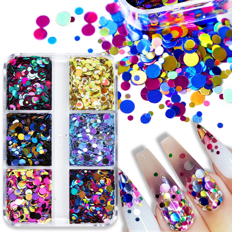 A set of colorful glitter nail art sequins in round shape, displayed in a clear plastic case and scattered on a surface with a manicured nail showing the sequins adhered to it.