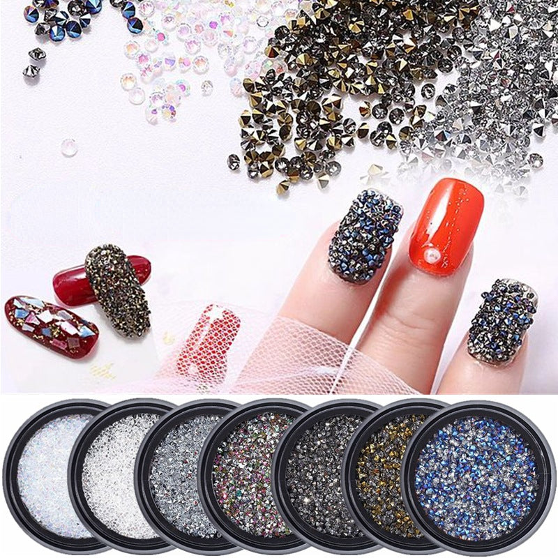 A collection of multicolored 3D crystal rhinestone decorations for nail art displayed on a manicured hand and in separate compartments.